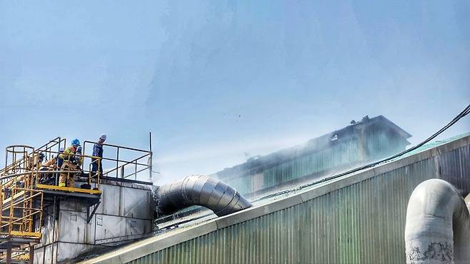 10일 울산 울주군 온산읍 이진리 KG케미칼 비료생산공장에서 화재가 발생해 출동한 소방관들이 불이 시작된 지붕 쪽으로 물을 쏘고 있다. 울산소방본부 제공