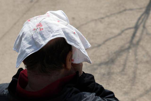지난달 14일 서울 용산구 이촌한강공원에서 꽃무늬 손수건을 머리에 쓴 시민이 휴식을 취하는 모습. 10여 년째 손수건 쓰기 캠페인을 지속하고 있는 표혜령 한국화장실문화협회 대표는 "지금까지는 '손수건 쓰기 캠페인'을 국가 차원에서 본격적으로 전개한 적이 없는 만큼, 이제부터라도 인식 개선에 나서야 한다"고 강조했어요. 연합뉴스