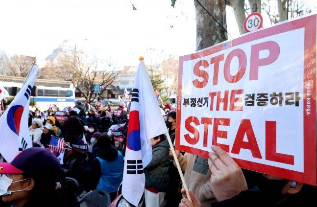 윤석열 전 대통령 지지자들이&nbsp;지난 2월23일&nbsp;서울 종로구 헌법재판소 인근에서&nbsp;부정선거 의혹을 제기하며 팻말을 들고 있다. 연합뉴스