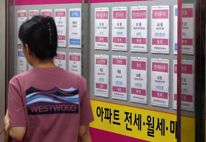한 시민이 서울의 한 부동산 중개업소 앞에 게시된 매물 정보 앞을 걸어가고 있다. 최근 매수심리 위축과 전세대출 제약 여파로 매물은 줄고 거래는 감소하며, 실수요자들도 ‘관망’에 들어간 분위기다. 뉴시스