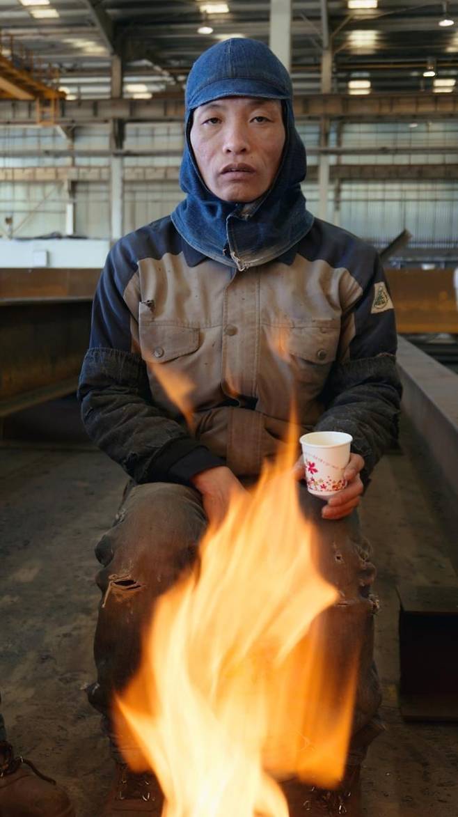 베트남에서 온 외국인 노동자가 불을 쬐고 있다. 2017년 경기도 화성/ 사진가 심학철