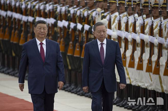 [베이징=AP/뉴시스] 중국 외교부는 11일 대변인 명의의 공지를 통해 시진핑 국가주석이 오는 14일부터 18일까지 베트남과 말레이시아, 캄보디아 등 동남아 3국을 방문한다고 밝혔다. 사진은 시 주석(왼쪽)과 또 럼 베트남 서기장이 지난해 8월 19일 베이징 인민대회당에서 국빈방문 환영식에 참석해 중국군 의장대를 사열하는 모습. 2025.04.11