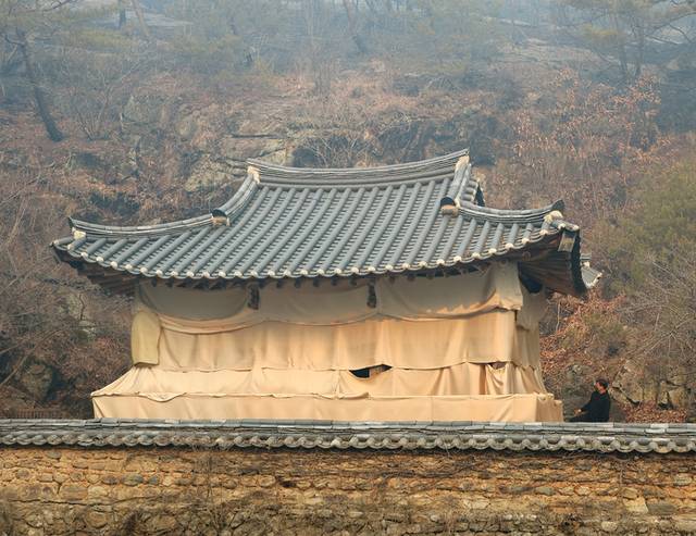 소방관, 공무원들이 ‘만휴정’에 망염포를 덮고 물을 뿌려 산불로 인한 화재를 막았다. 연합뉴스