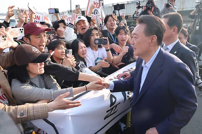 윤석열 전 대통령이 11일 오후 서울 용산구 한남동 관저에서 퇴거하면서 지지자들에게 손을 들어 인사하고 있다. 관저 정문 앞 도로 양옆에는 윤 전 대통령 지지자 2000여 명(경찰 비공식 추산)이 모였다./김지호 기자
