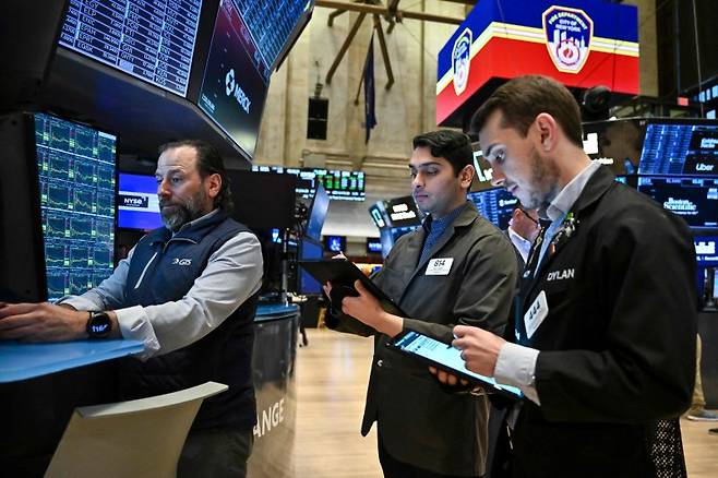 뉴욕증권거래소에서 중개인들이 지난 8일 채권 시장의 수익률 급등에 우려스러운 표정으로 관련 수치들을 바라보고 있다. AFP 연합뉴스