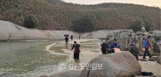 ▲ 최북단 고성군 죽왕면 송지호 해변과 무인도 대섬을 연결하는 바닷길이 열려 눈길을 끌고 있다. 고성지역의 봉사단체인 ‘맨발행복’ 회원들이 밀려든 해양쓰레기를 치우며  동해안의 홍해로 불리는 이곳의 관광자원화에 힘을 보태고 있다.