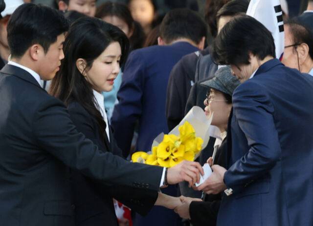 윤석열 전 대통령 배우자&nbsp;김건희 여사가 지난 11일 서울&nbsp;서초구 사저로 들어가기 전 지지자들에게 꽃다발을 받고 있다. 뉴시스&nbsp;