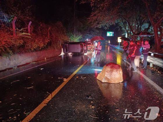 12일 오후 9시 46분쯤 전남 구례군 토지면의 한 도로변에서 바위가 떨어지면서 차가 전도돼 소방당국이 차량에 고립된 운전자 1명을 구조하고 있다. (구례소방 제공. 재판매 및 DB금지)