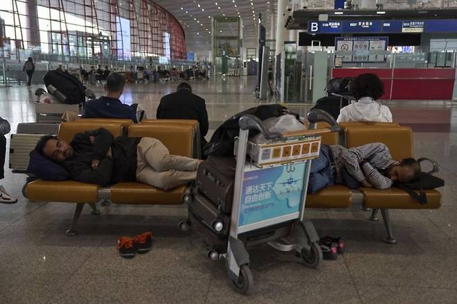 강풍 경보로 베이징 항공편이 취소되자 승객들이 수도 국제공항 제3터미널에서 항공편을 기다리며 자고 있다. AP연합뉴스