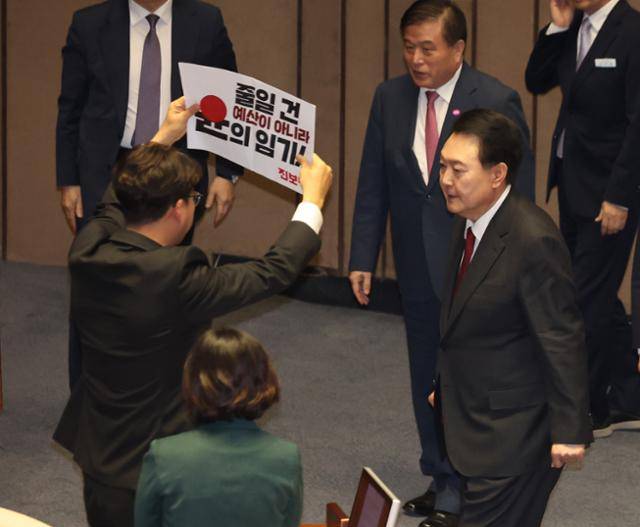 윤석열 전 대통령이 2023년 10월 31일 국회에서 열린 2024년 예산안 시정연설을 마친 후 본회의장을 나서자 강성희 진보당 의원이 손팻말을 들고 있다. 고영권 기자