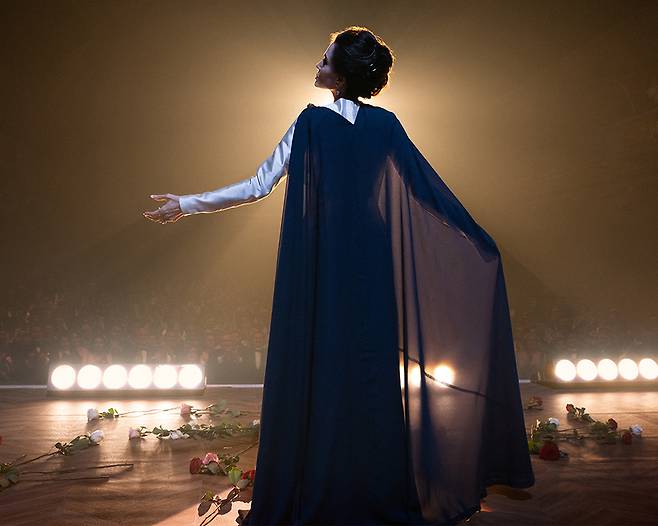 영화 <마리아>에서 성악가 마리아 칼라스(안젤리나 졸리)가 무대 위에서 스포트라이트를 받고 있다. 판씨네마 제공