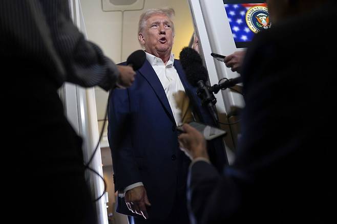 도널드 트럼프 미국 대통령이 11일(현지시간) 플로리다주로 향하는 대통령 전용기 안에서 기자들의 질문을 받고 있다. 연합뉴스