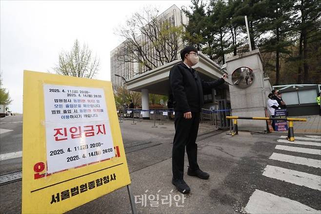 내란 우두머리 혐의로 기소된 윤석열 전 대통령의 첫 정식 형사재판이 열리는 14일 오전 서울 서초구 서울중앙지방법원 출입구가 통제되고 있다. ⓒ사진공동취재단
