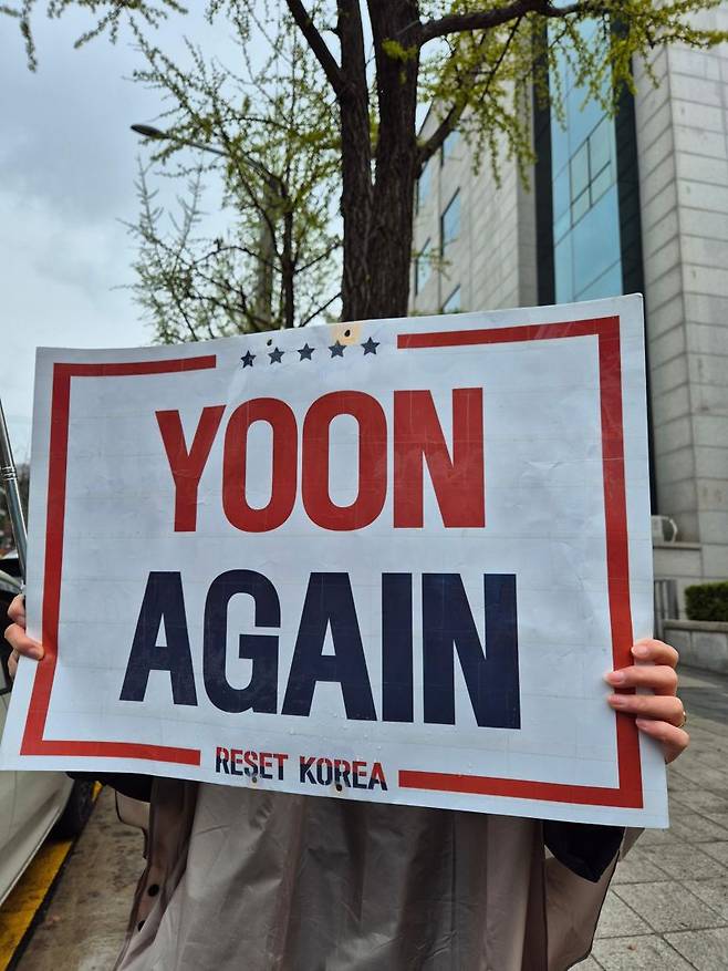 14일 서울 서초구 소재 서울중앙지방법원 등기국 쪽 거리에서 윤석열 전 대통령 지지자가 'YOON AGAIN' 구호가 새겨진 팻말을 들고 있다. 사진=김예지 기자