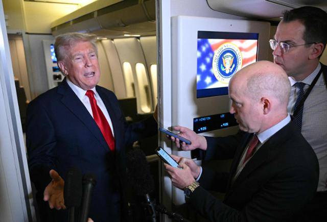 도널드 트럼프 미국 대통령이 13일 플로리다주 팜비치에서 워싱턴으로 향하는 대통령 전용기 안에서 기자들의 질문에 답하고 있다. AFP 연합뉴스