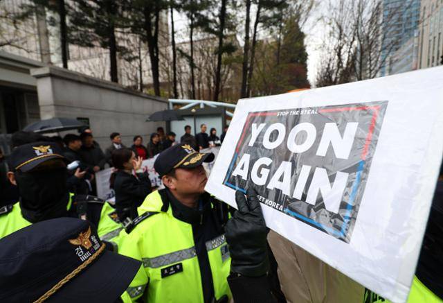 윤석열 전 대통령 첫 공판이 열린 14일 서울 서초구 서울중앙지법 앞에서 윤 전 대통령 지지자가 손팻말을 들고 있다. 연합뉴스