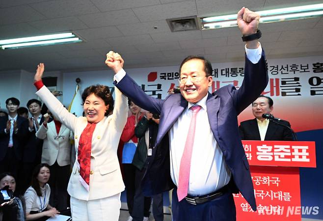 홍준표 전 대구시장(오른쪽)이 14일 오후 서울 여의도 대하빌딩 캠프 사무소에서 제21대 대통령 선거 출마 선언을 하며 부인 이순삼 씨와 함께 손을 들어보이고 있다. 