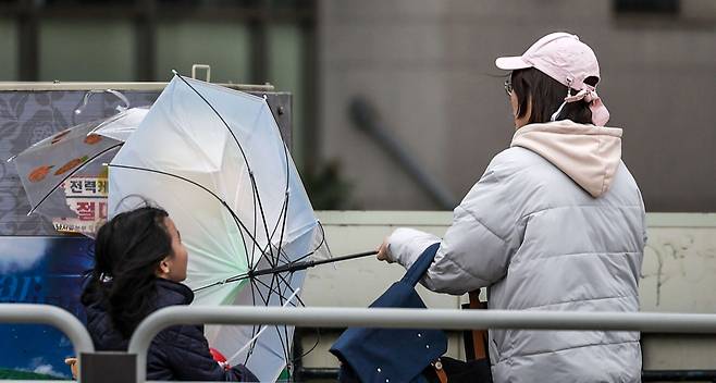 서울 시내에 강풍을 동반한 우박이 내린 13일 서울 영등포구 여의서로에서 시민이 쓴 우산이 강풍에 뒤집히고 있다. 뉴시스