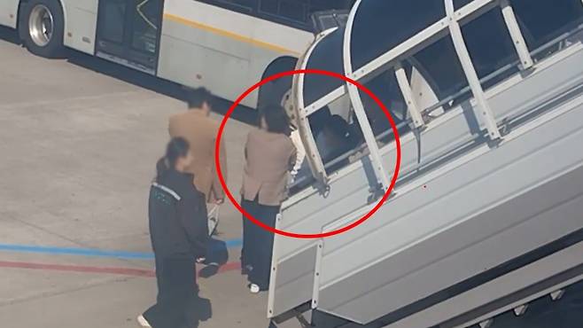 오늘(15일) 아침 8시 10분쯤 제주국제공항을 출발해 김포공항으로 향하려던 에어서울 항공기 비상문을 개방한 30대 여성이 경찰에 인계되는 모습 (사진, 시청자 제공)