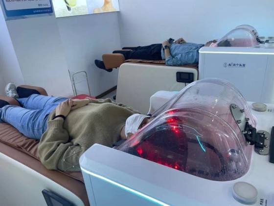 중국 광저우에 기기가 머리를 감겨주는 'AI 샴푸 전문점'이 등장했다. 광저우일보 캡처=연합뉴스