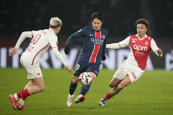 Paris Saint-Germain midfielder Lee Kang-in, center, vies for the ball during a Ligue 1 match against AS Monaco at Parc des Princes in Paris on Feb. 7. [AP/YONHAP]