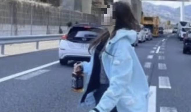 중국인 여성 2명이 사고가 발생해 정체된 고속도로 한가운데에 누워 양팔을 위로 올린 채 인증 사진을 찍었다. 또 오른손에 위스키 병을 들거나 캐릭터 가방을 안은 채 또 다른 인증 사진을 찍는가 하면 차에서 반려견을 데리고 내려 고속도로 위에서 산책시키는 장면을 영상에 담기도 했다/사진=X(옛 트위터)