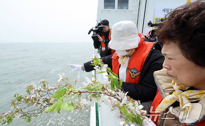 세월호 참사 11주기인 16일 오전 전남 진도군 동거차도 인근 세월호 참사 해역에서 열린 선상 추모식에서 2학년 9반 배향매 양의 어머니 진복순 씨 등 유가족이 안산 단원고 앞에서 꺾어온 벚꽃 가지를 날리고 있다. 2025.4.16/뉴스1 ⓒ News1 이수민 기자