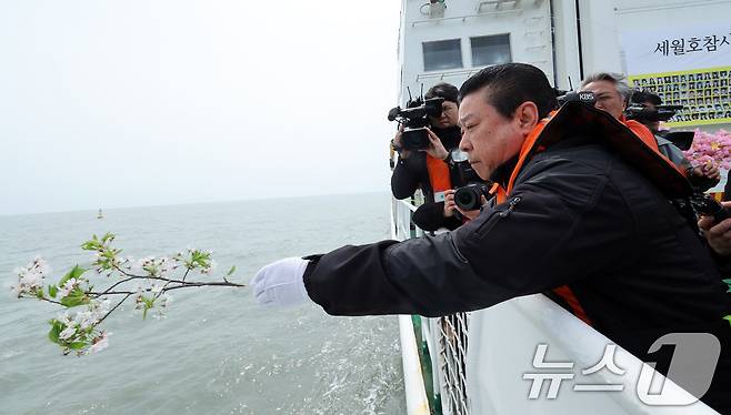 세월호 참사 11주기인 16일 오전 전남 진도군 동거차도 인근 세월호 참사 해역에서 열린 선상 추모식에서 2학년 9반 배향매 양의 아버지 배희춘 씨 등 유가족이 안산 단원고 앞에서 꺾어온 벚꽃 가지를 날리고 있다. 2025.4.16/뉴스1 ⓒ News1 이수민 기자