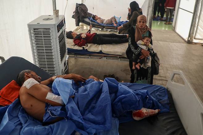 15일(현지시간)  이스라엘군 폭격으로 파괴된 가자지구 알아흘리 아랍 병원에서 대피한 팔레스타인 환자들이 쿠웨이트 적신월사 야전 병원에서 치료를 받고 있다. 신화연합뉴스