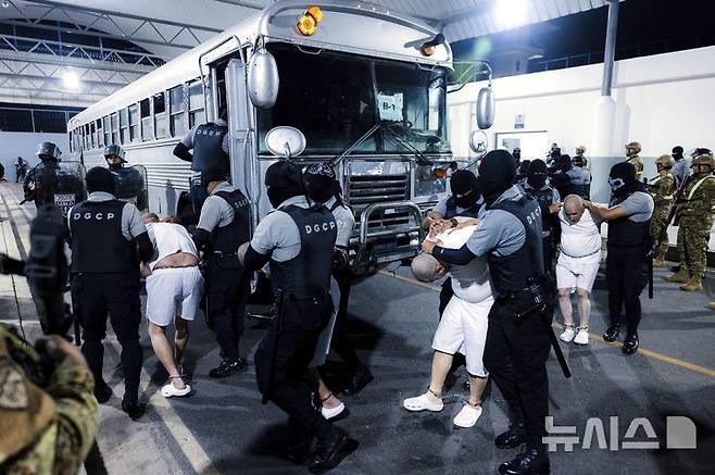 [테콜루카=AP/뉴시스] 지난달 31일(현지 시간) 엘살바도르 테콜루카 '테러범 수용소'(CECOT·세코트)에서 교도관들이 미국으로부터 추방된 이주자들을 압송하고 있다. 미국이 베네수엘라 갱단 조직원으로 지목해 추방한 이들 가운데 실제 조직원인 사람은 거의 없는 것으로 전해진다. 2025.4.16.