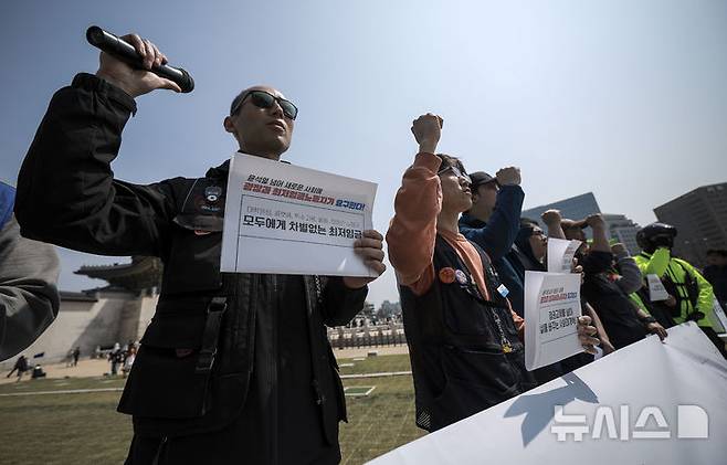 [서울=뉴시스] 정병혁 기자 =14일 서울 종로구 광화문 월대에서 열린 공공운수노조 최저임금 투쟁 선포 기자회견에서 공공운수노조 조합원들이 구호를 외치고 있다.  2025.04.16. jhope@newsis.com