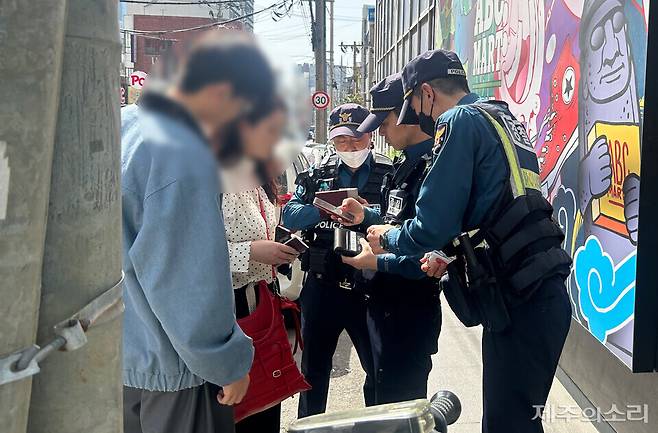 17일 오후 제주시 연동 누웨마루 거리 일대에서 무단횡단하다 경찰에 적발된 중국 국적 20대 남녀 관광객. ⓒ제주의소리