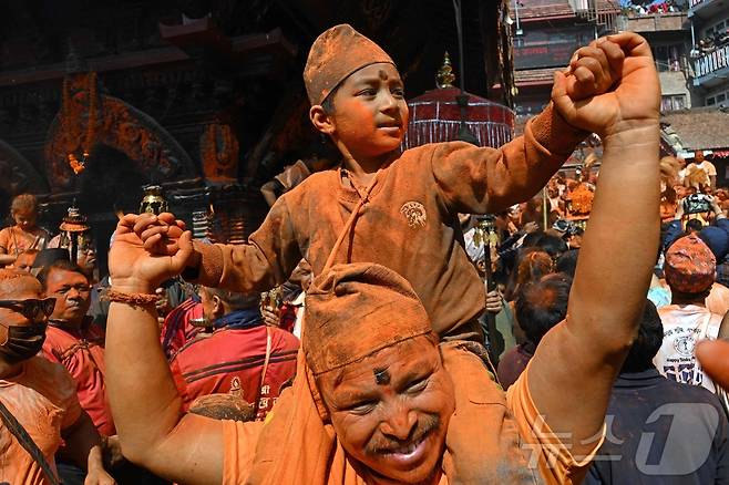 15일(현지시간) 네팔 카트만두에서 열린 신두르 자트라 축제에서 시민들이 주홍 가루를 뿌리며 축제를 즐기고 있다.  ⓒ AFP=뉴스1