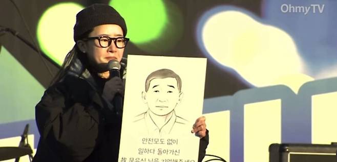 산재 사고로 사망한 고 문유식씨 딸 문혜연씨가 지난 1월4일 ‘윤석열 퇴진’ 광화문 광장 무대에 올라 손팻말을 들고 발언하는 모습. 문혜연씨 제공
