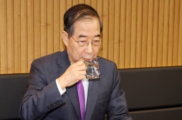 물 마시는 한덕수 권한대행 - 한덕수 대통령 권한대행 국무총리가 16일 결식 아동들에게 무료 점심을 제공해온 울산 뚠뚠이 돈가스에서 사장과 직원들을 격려한 후 물을 마시고 있다. 2025.4.16 연합뉴스