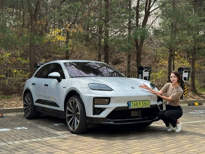 나연진 글로벌이코노믹 기자가 아이스 그레이 메탈릭 색상의 신형 포르쉐 마칸 일렉트릭 터보와 함께 포즈를 취하고 있다. 사진=나연진 글로벌이코노믹 기자