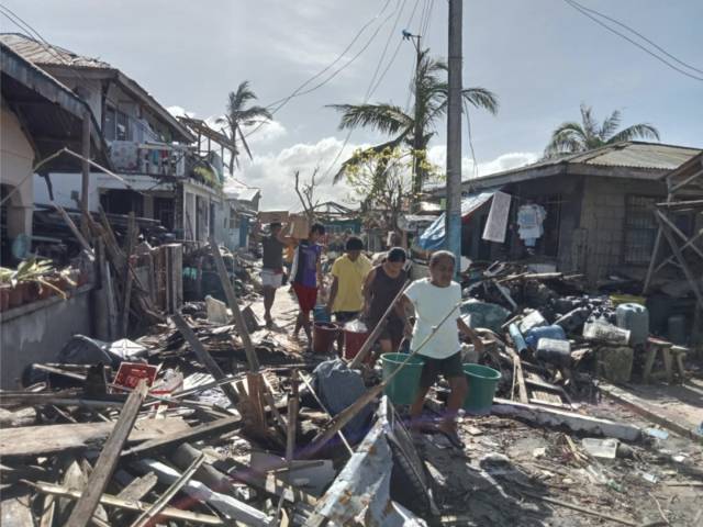 ▲태풍 라이가 지나간 후, 바타산섬 주민들이 마을 피해 지역을 걷고 있다. ⓒ그린피스
