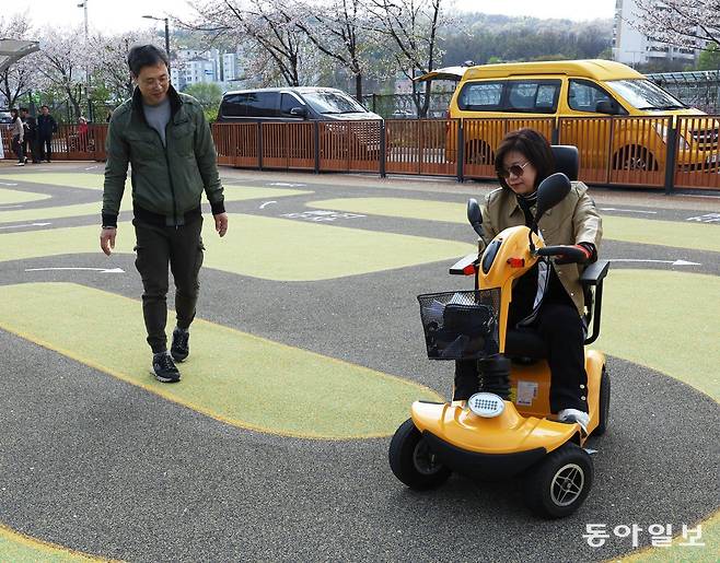 15일 서울 노원구 전동보장구 운전연습장에서 한 수강생(오른쪽)이 전동스쿠터 운전 요령을 강사에게 배우고 있다. 바닥에는 전동스쿠터가 주행해야 하는 방향이 화살표로 표시돼 있다. 이 연습장은 지난해 11월 문을 열었다. 신원건 기자 laputa@donga.com