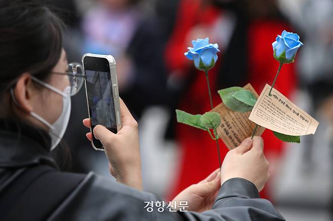 세계여성의날인 2023년 3월 8일 서울 서대문구 이화여대에서 학생들이 여성의 삶을 응원하는 메시지를 담은 비누 장미를 시민단체로부터 받은 뒤 사진을 찍고 있다. 성동훈 기자