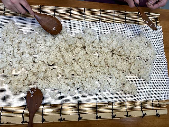 Sweet rice is spread on gauze to cool during Suguk's makgeolli-making class on Monday. (Lim Jae-seong/The Korea Herald)
