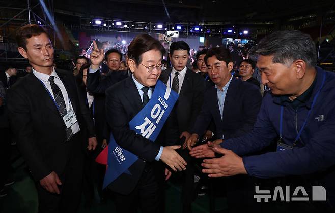 [청주=뉴시스] 조성봉 기자= 이재명 제21대 대통령 선거 더불어민주당 경선 후보가 19일 오후 충북 청주시 서원구 청주체육관에서 열린 제21대 대통령선거 후보자 선출을 위한 충청권 합동연설회에서 1위를 기록, 지지자들에게 축하를 받고 있다. 2025.04.19. suncho21@newsis.com