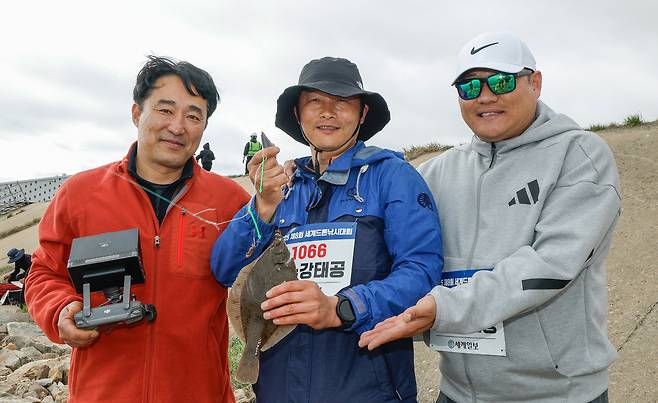 세계일보 주최로 19일 충남 당진드론산업지원센터 앞 석문방조제 일원에서 제8회 세계드론낚시대회가 열린 가운데 1위를 기록한 여수강태공 팀이 낚은 도다리를 들고 기념촬영을 하고 있다.