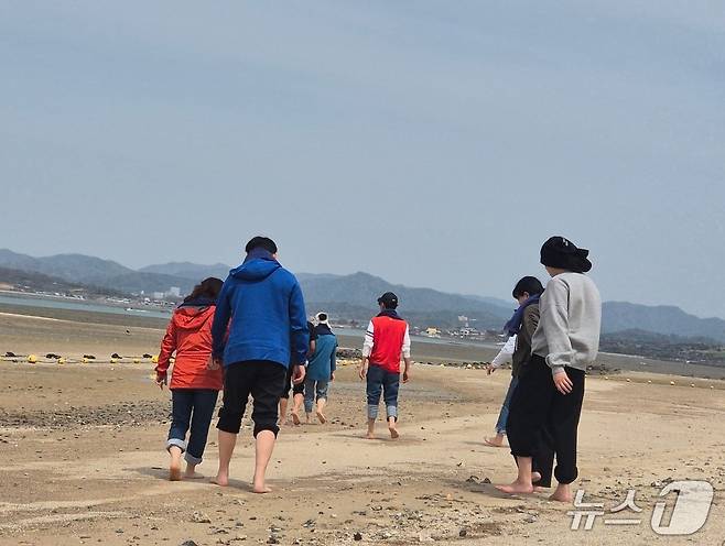 지난 16일부터 이틀간 밀알복지재단은 13명의 시각, 청각 또는 시청각 장애인(장애 당사자), 활동지원사들과 함께 '오감만족 여행'을 진행했다. 전남 함평 돌머리해수욕장을 거니는 당사자들과 활동지원사들의 모습. 2025.4.17/뉴스1 ⓒ News1 남해인 기자