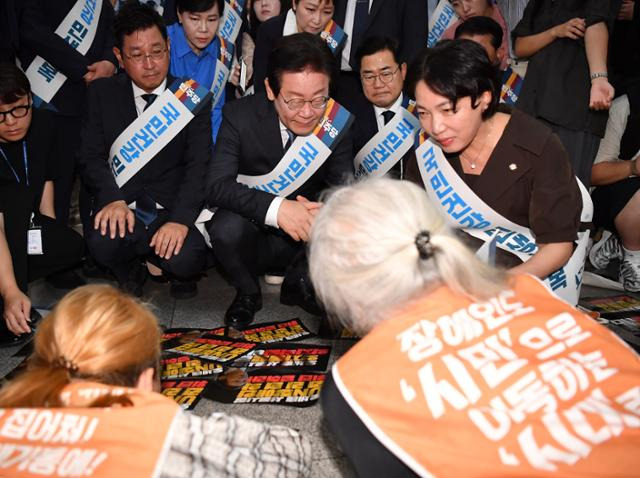 이재명 전 더불어민주당 대표가 2024년 9월 13일 서울 용산구 용산역에서 추석 귀성인사를 하던 도중 박경석 전국장애인차별철폐연대(전장연) 대표의 7대 장애인권리입법 제정 호소를 듣고 있다. 고영권 기자