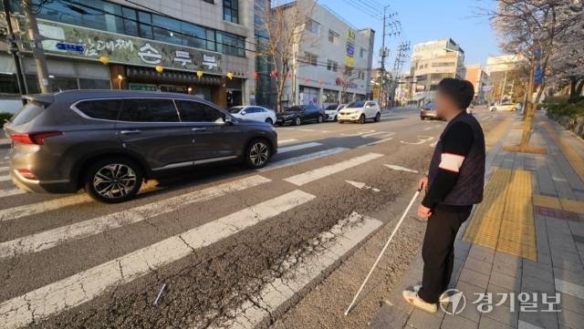 19일 오후 6시께 서구 큰솔장애인자립생활센터 앞 도로. 시각장애인 김준영씨가 음향신호기 없는 횡단보도에서 계속 오는 차에 건널 타이밍을 잡지 못하고 있다. 박기웅기자