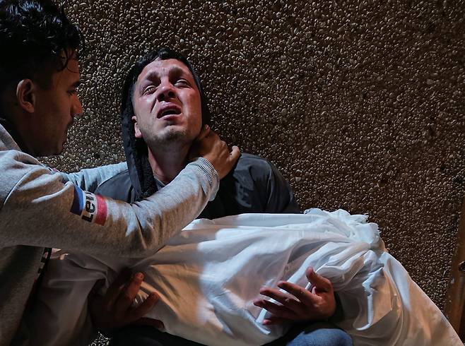 3월30일 팔레스타인 가자지구 알-아흘리 병원에서 이스라엘의 공습으로 숨진 희생자 가족이 시신을 안고 슬퍼하고 있다. ⓒTASS 연합