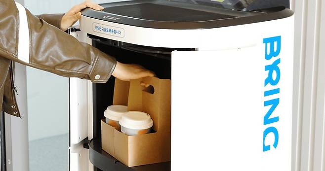 카카오모빌리티의 로봇 배송 서비스 '브링'(BRING)을 이용해 커피를 배달하는 모습 (카카오모빌리티 제공)