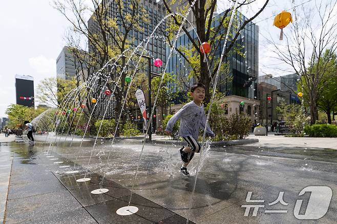 서울 낮 최고기온이 26도를 기록하는 등 초여름 날씨를 보인 21일 서울 세종대로 광화문광장 터널분수에서 어린이가 더위를 식히고 있다. 2025.4.21/뉴스1 ⓒ News1 이승배 기자