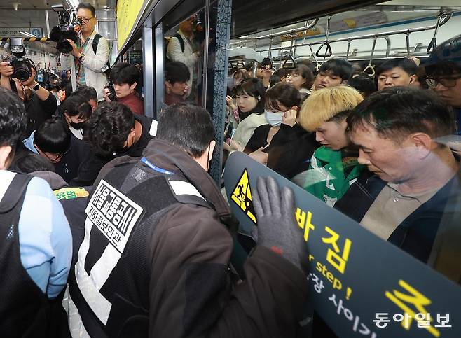전국장애인차별철폐연대(전장연)의 출근길 지하철 탑승 시위가 1년여 만에 재개된 21일 서울 지하철 4호선 혜화역에서 전장연 회원이 지하철 탑승을 시도하다 서울교통공사 관계자와 충돌하고 있다.

    송은석 기자 silverstone@donga.com