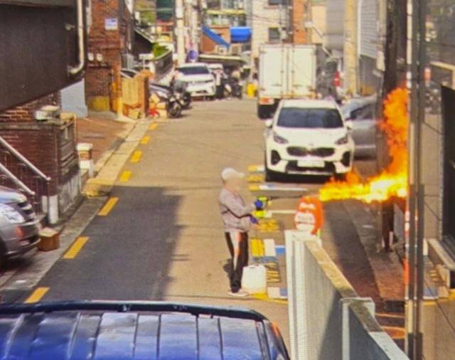 봉천동 아파트 방화 용의자 이모씨가 21일 서울 관악구 봉천동 한 빌라 앞에서 고압세척건을 이용해 불을 지르고 있다. 연합뉴스